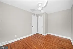 a view of a room with wooden floor and ceiling fan