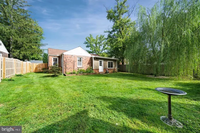 a front view of a house with garden and trees