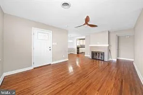 a view of a livingroom with wooden floor and a ceiling fan