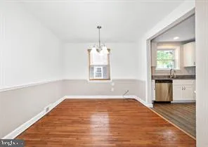 a view of a kitchen with a sink dishwasher and wooden floor