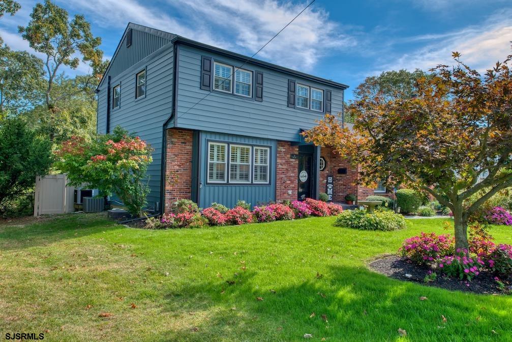 a front view of house with a garden