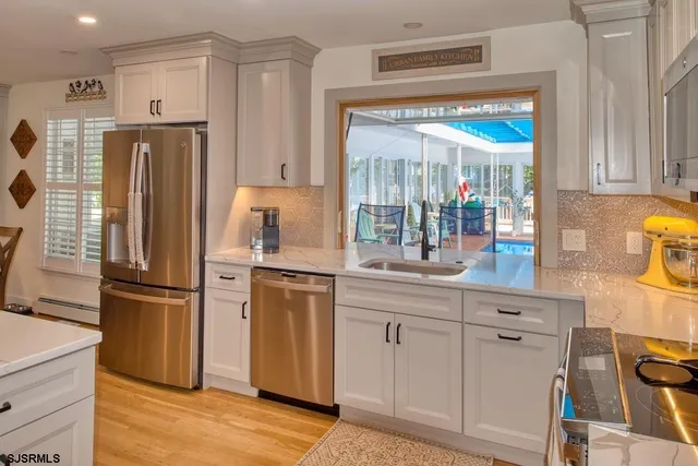 a kitchen with stainless steel appliances a sink stove and cabinets