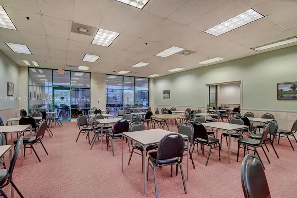 a outdoor space with lots of tables a large window and chairs