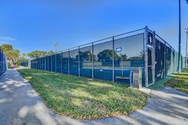 a view of a tennis ground with large trees