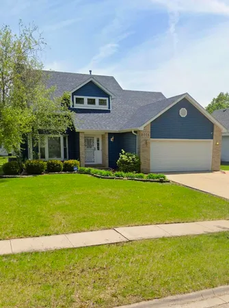 a front view of a house with a garden and yard