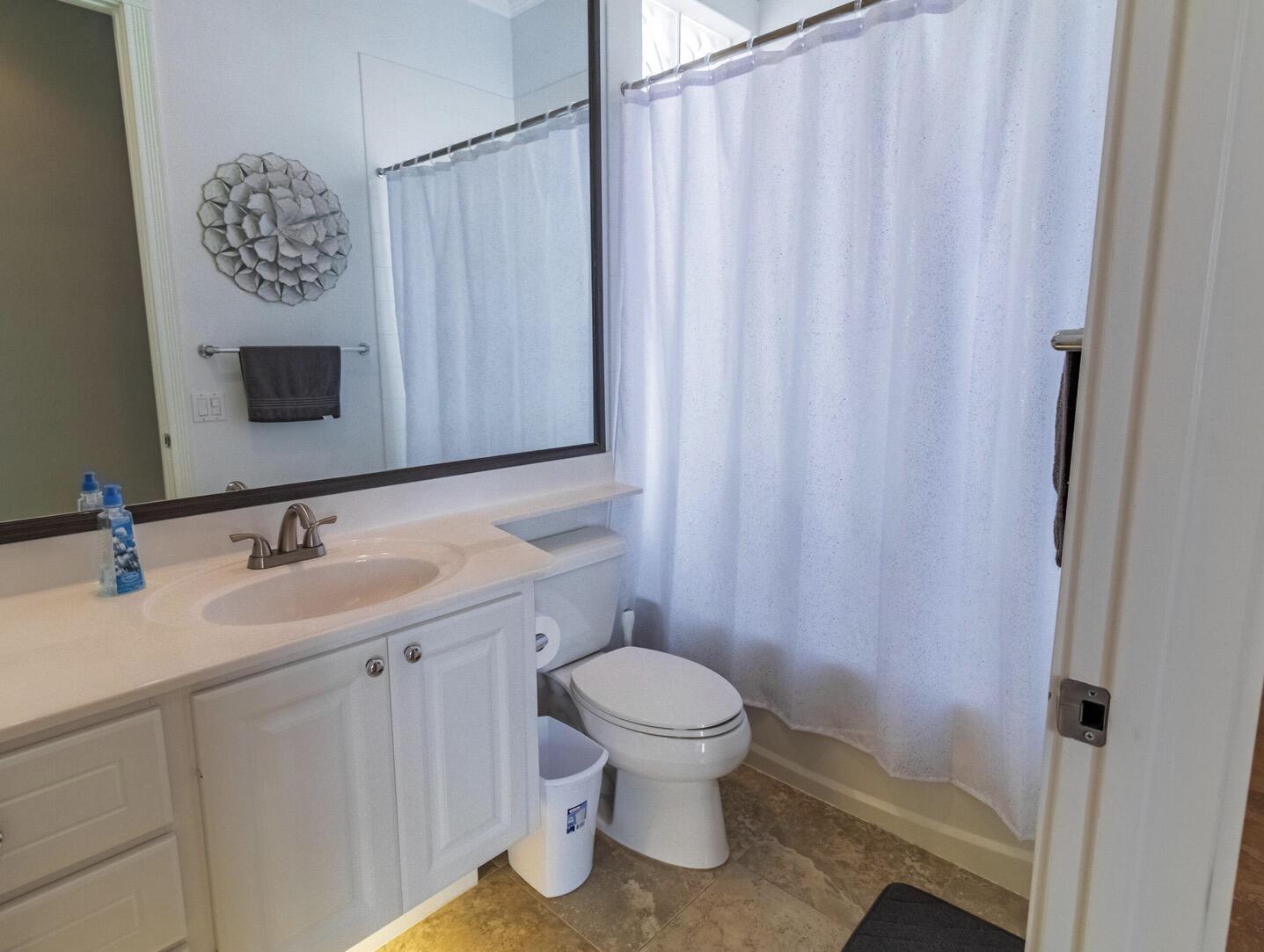 11355 Southwest Rockingham Drive Port St. Lucie, FL 34987 - Photo 19 of 31 a bathroom with a toilet a sink and a mirror
