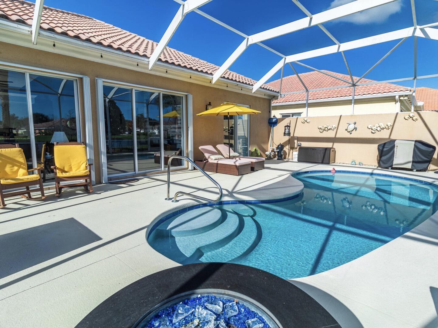 11355 Southwest Rockingham Drive Port St. Lucie, FL 34987 - Photo 22 of 31 a view of a patio with table and chairs under an umbrella