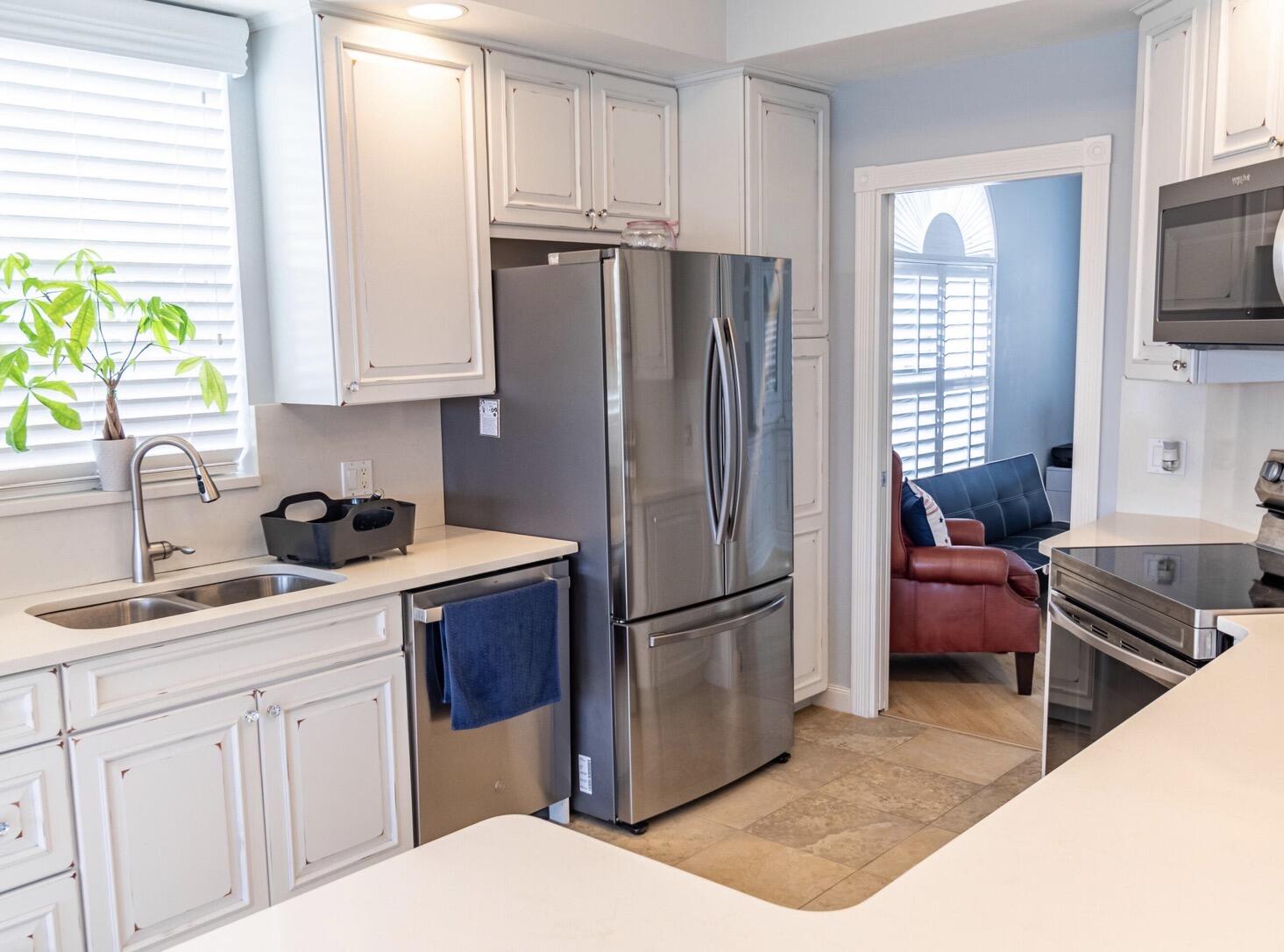 11355 Southwest Rockingham Drive Port St. Lucie, FL 34987 - Photo 7 of 31 a kitchen with a refrigerator sink and white cabinets