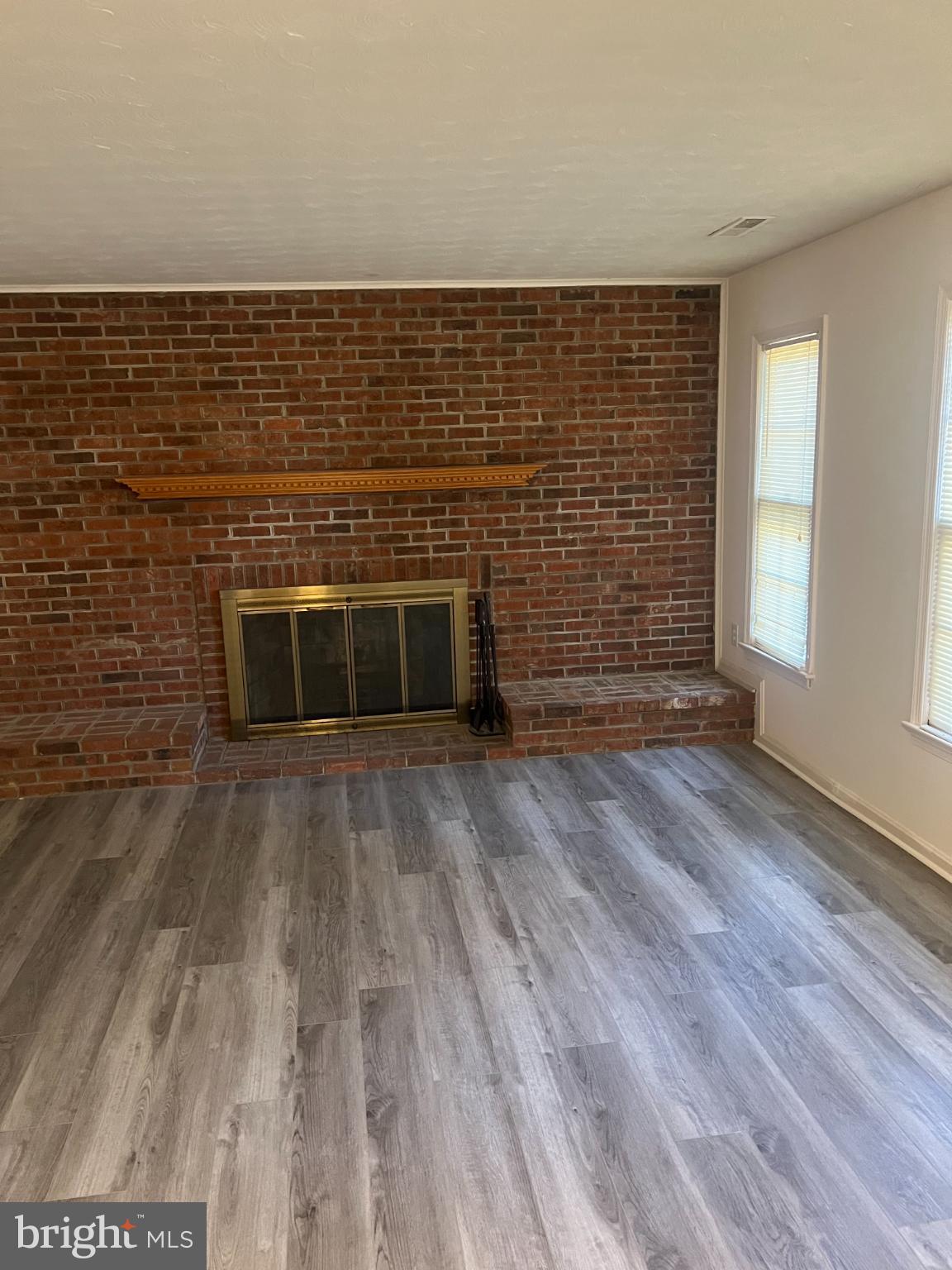 215 Summit Hall Road Gaithersburg, MD 20877 - Photo 13 of 20 a view of empty room with wooden floor and fireplace