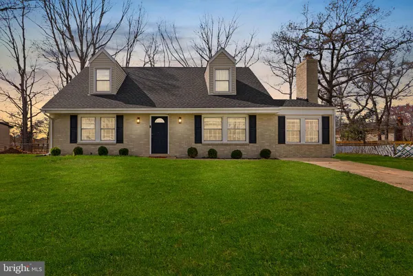 a front view of a house with a garden and trees