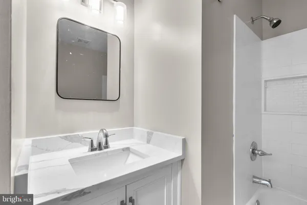 a bathroom with a sink vanity and mirror