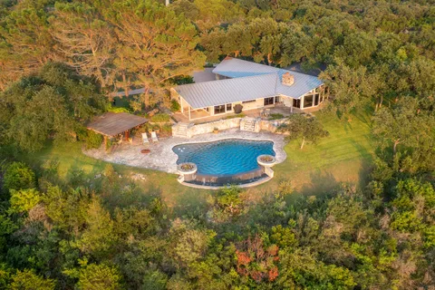 a view of a house with pool and a yard