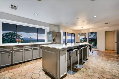 a kitchen with stainless steel appliances granite countertop a sink and a refrigerator