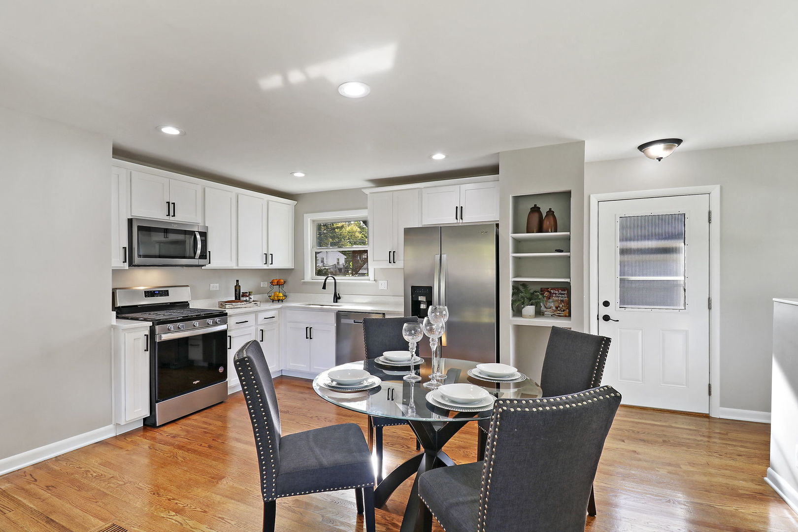 111 Wagner Drive Cary, IL 60013 - Photo 5 of 23 a kitchen with stainless steel appliances a dining table chairs stove refrigerator and cabinets