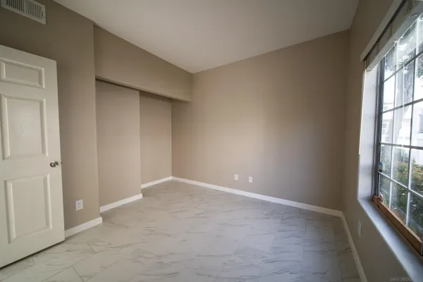 a bedroom with a bed and a large window