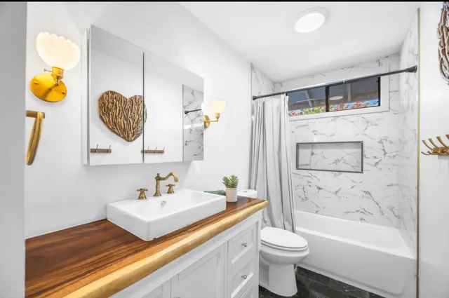 a bathroom with a granite countertop sink a toilet and a mirror