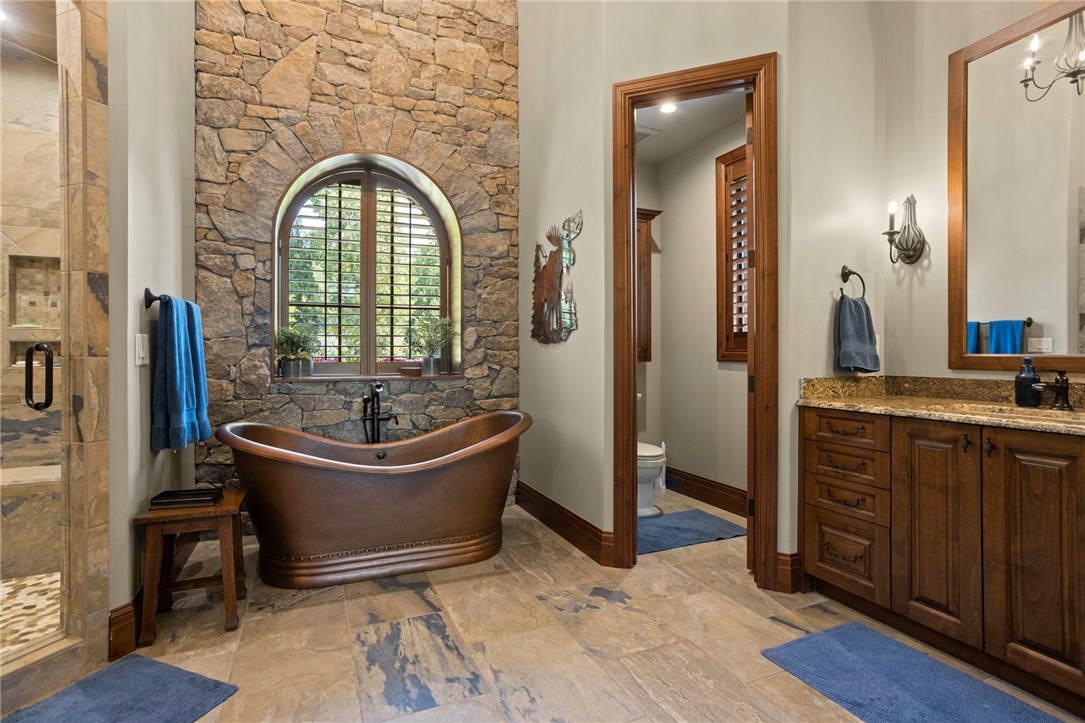 236 Palmer Way Sunset, SC 29685 - Photo 16 of 46 A copper soaking tub is framed by an arched stone wall, creating a rustic and serene bathroom escape.