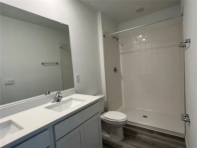a bathroom with a sink a toilet and shower