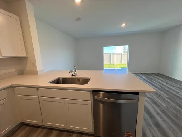 a kitchen with a sink cabinets and wooden floor
