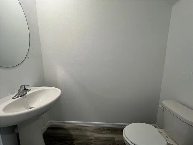 a bathroom with a toilet a sink and mirror