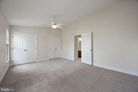 an empty room with a ceiling fan and a window