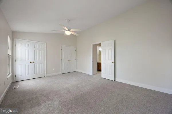 an empty room with a ceiling fan and a window