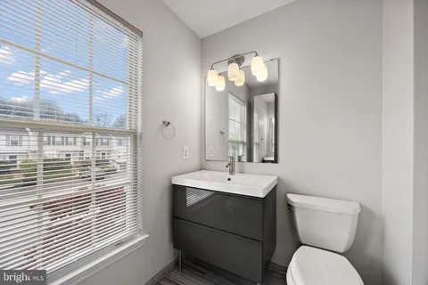 a bathroom with a toilet a sink and mirror