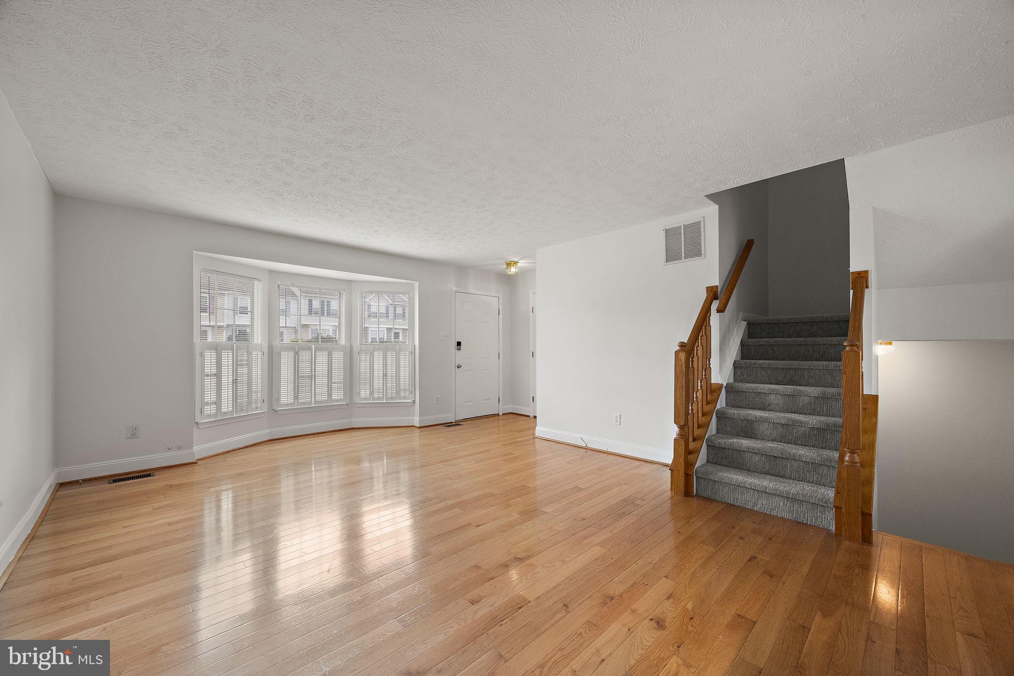 104 West Shetland Court Newark, DE 19711 - Photo 5 of 22 a view of an empty room with wooden floor and stairs