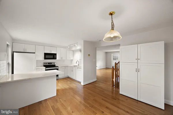 a kitchen view with stainless steel appliances a refrigerator and a microwave