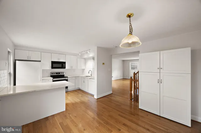 a kitchen view with stainless steel appliances a refrigerator and a microwave
