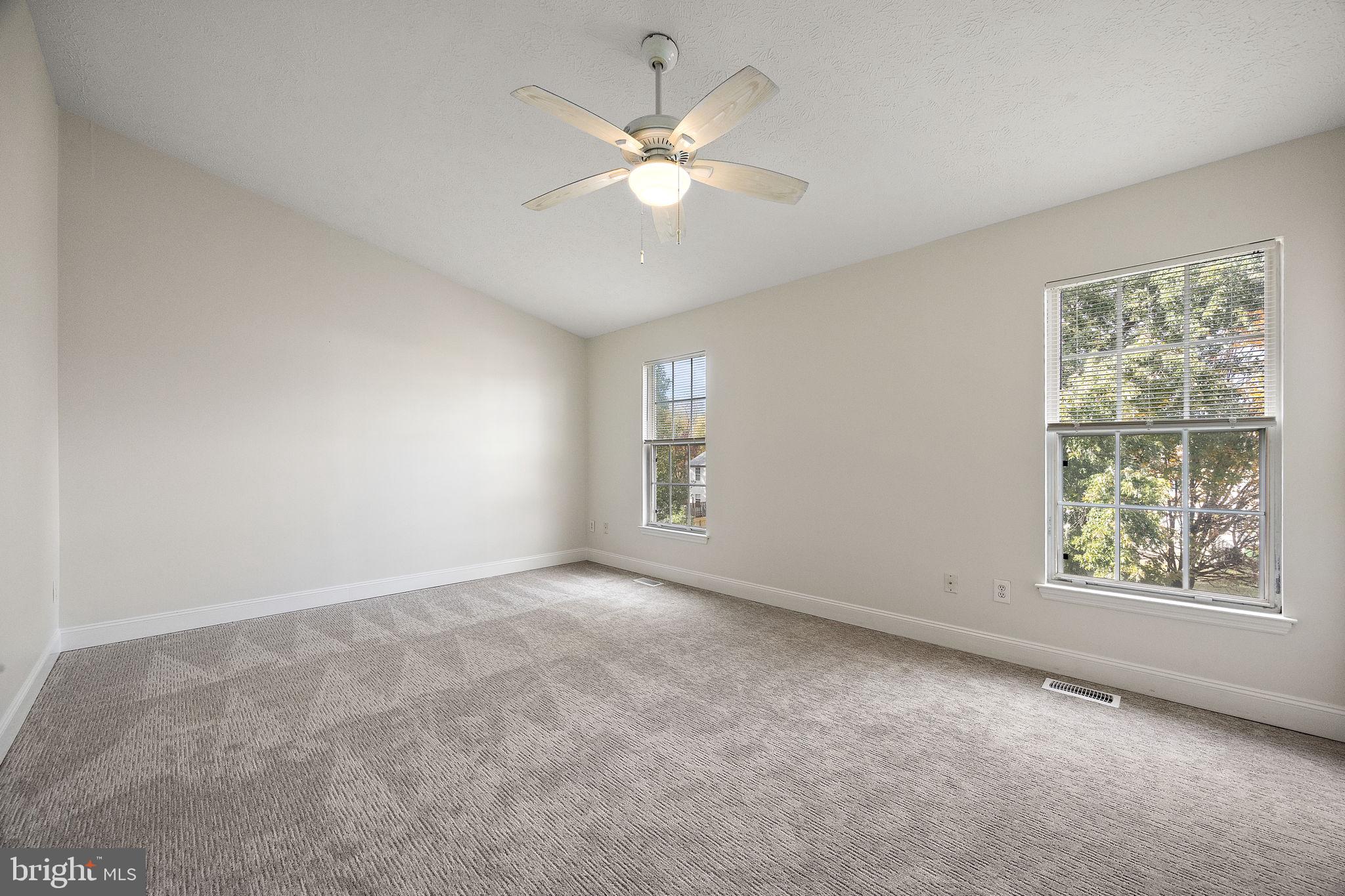 104 West Shetland Court Newark, DE 19711 - Photo 10 of 22 an empty room with windows and chandelier fan