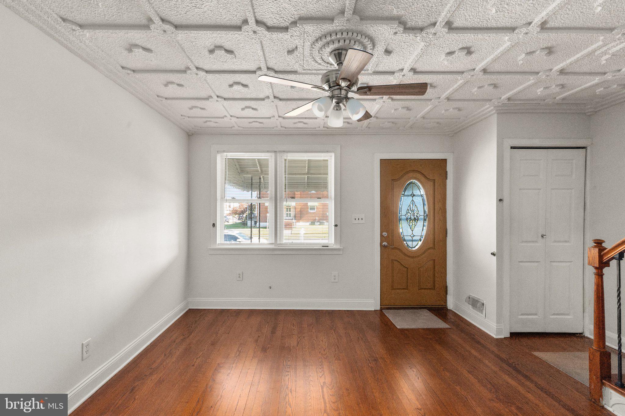 2900 Plainfield Road Dundalk, MD 21222 - Photo 3 of 27 an empty room with wooden floor chandelier and windows