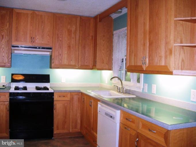 6104 Ridge Tree Road Fredericksburg, VA 22407 - Photo 7 of 26 a kitchen with kitchen island granite countertop wooden cabinets a sink and a stove
