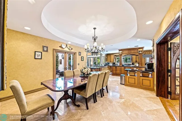 a dining room with furniture a kitchen and chandelier