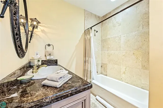 a bathroom with a granite countertop sink and a mirror