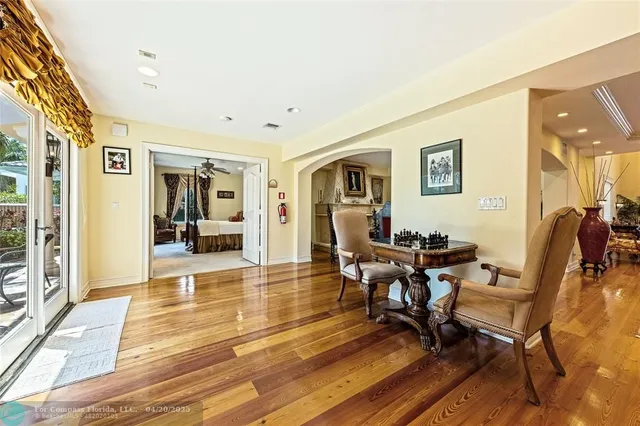 a living room with patio furniture and a wooden floor