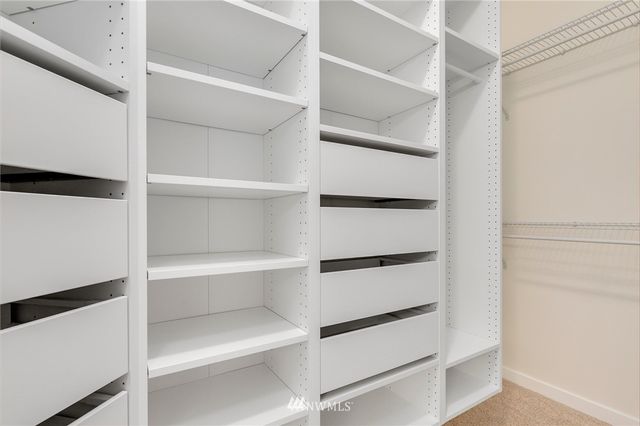 a view of walk in closet with empty racks