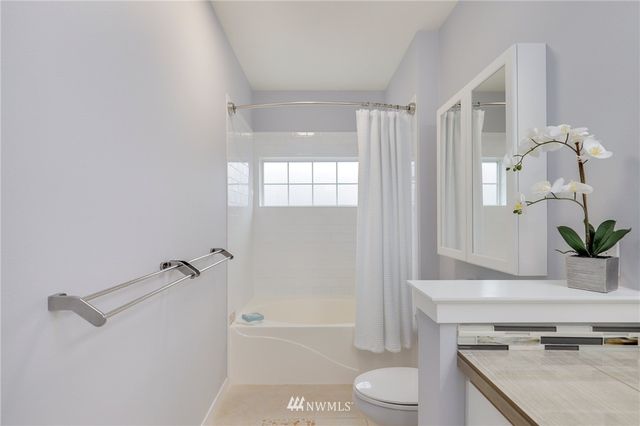 a bathroom with a granite countertop sink toilet a large mirror and shower