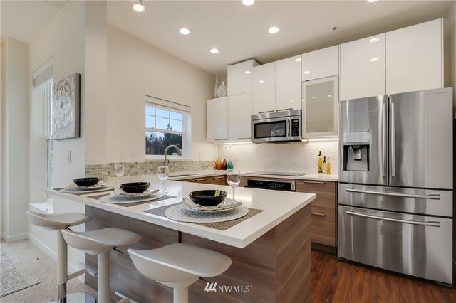 a kitchen with a sink a stove a refrigerator and chairs
