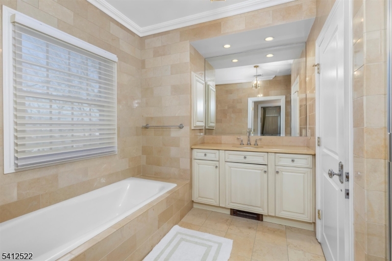 6 Harding Court Passaic, NJ 07055 - Photo 12 of 17 a bathroom with a granite countertop sink a bathtub and a mirror