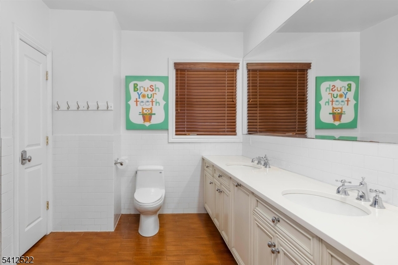 6 Harding Court Passaic, NJ 07055 - Photo 14 of 17 a bathroom with a granite countertop sink a large mirror a toilet and a window