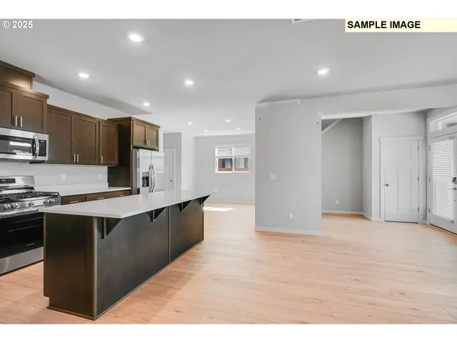 a large kitchen with stainless steel appliances granite countertop a sink and cabinets