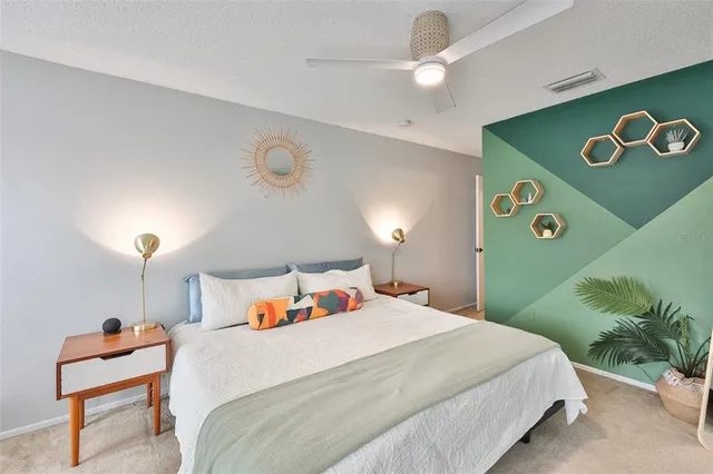 a bedroom with a bed and a lamp with potted plants