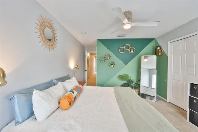 a bedroom with a bed and a large mirror on the dresser