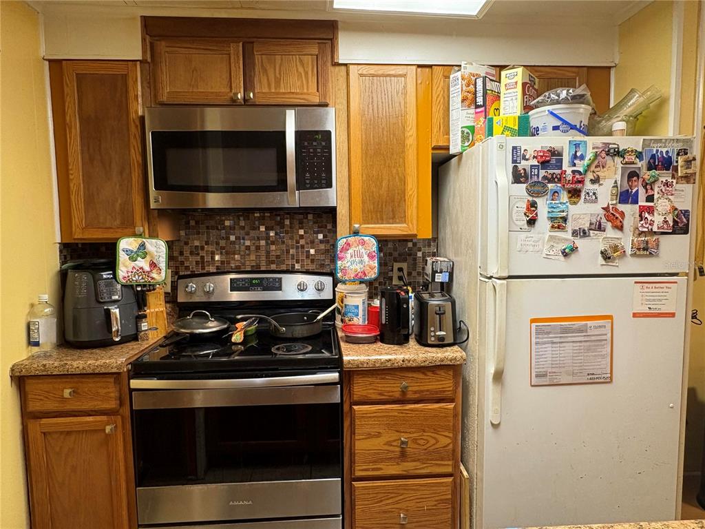 a kitchen with stainless steel appliances a stove a microwave and a refrigerator