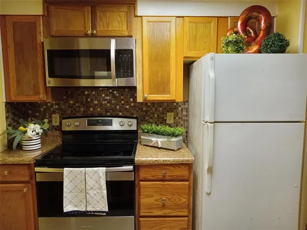 a kitchen with a refrigerator and a stove top oven