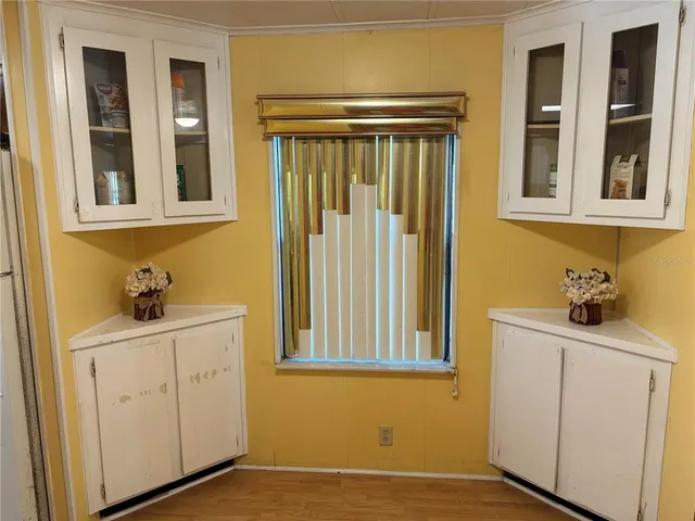 a view of an empty room with a window and a kitchen