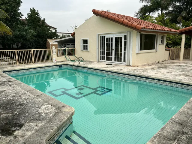 a view of a house with pool and a yard