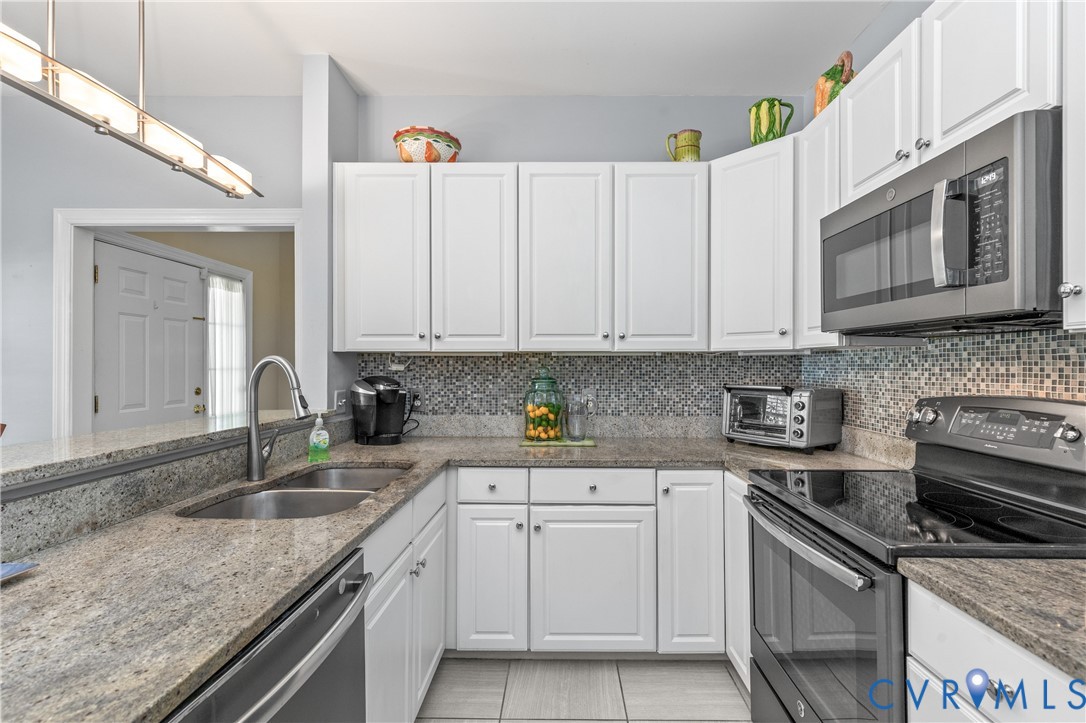 2205 Magnolia Grove Way Midlothian, VA 23113 - Photo 13 of 37 a kitchen with granite countertop white cabinets and stainless steel appliances