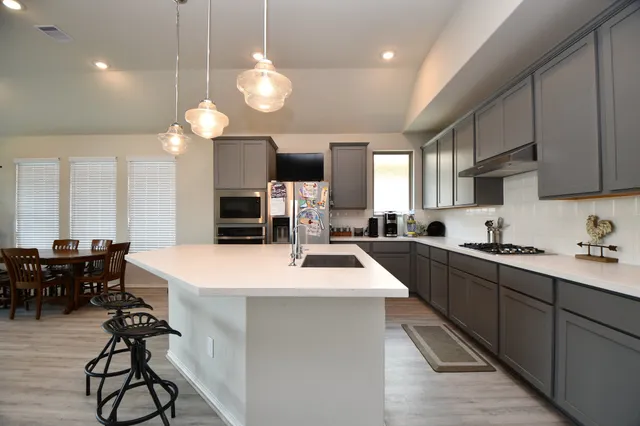 a large kitchen with kitchen island a dining table and chairs